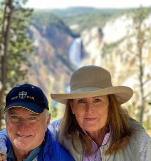 two older women standing in front of a mountain