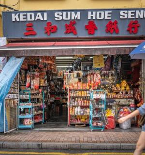 muž a žena procházející kolem obchodu s deštníkem