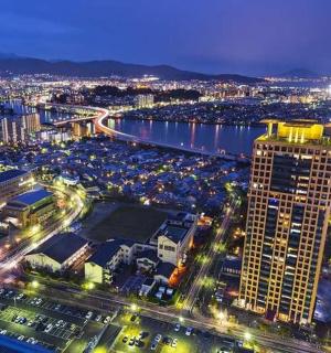 en by om natten med en flod og en høj bygning