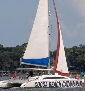 a white boat with a sail in the water