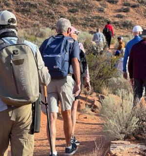a group of people walking on a dirt trail