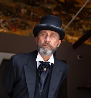 a man wearing a top hat and a suit and bow tie