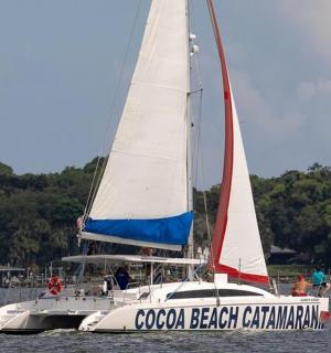 a white boat with a sail in the water