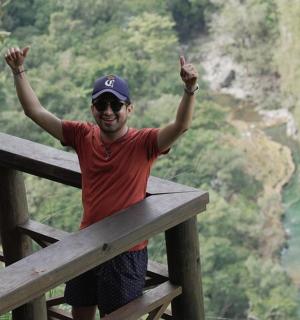 a man standing on a fence with his hands in the air