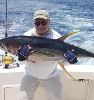 a man holding a large fish on a boat