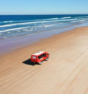 un camió vermell està aparcat a la platja