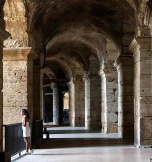 一名女子站在一座有柱子的建筑物里