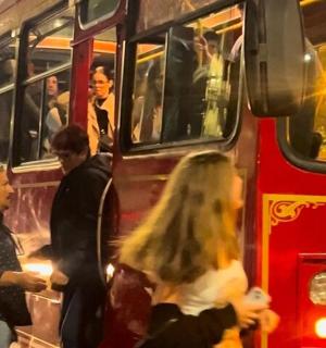 a group of people getting on a red bus