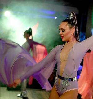 a woman in a bikini walking on a stage with an umbrella