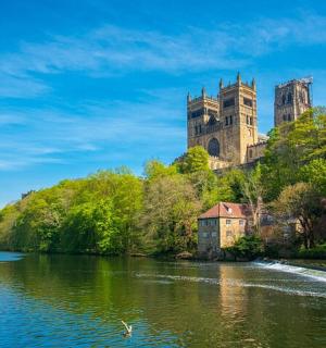 a castle sitting on top of a hill next to a river