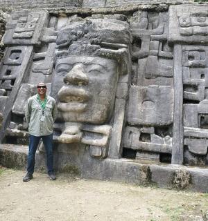 a man standing in front of a stone statue