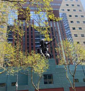 socha před vysokou budovou