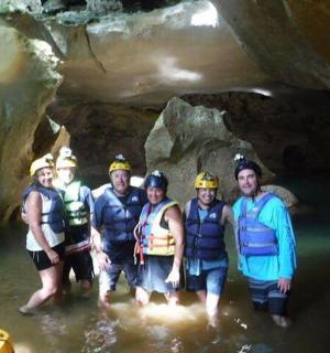 a group of people standing in the water in a cave