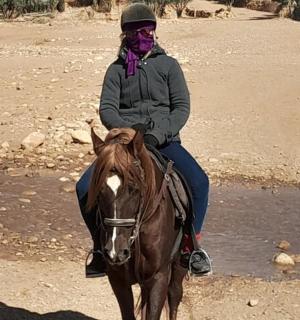 a woman riding a horse in the desert