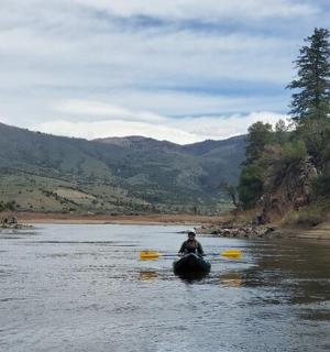 un uomo che cavalca un elefante lungo un fiume in kayak