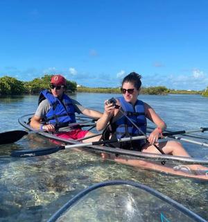 dva lidé sedící v kajacích na řece