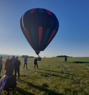 一群人站在田野里观看热气球