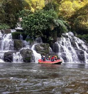 a group of people on a raft in front of a waterfall