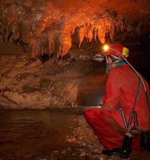 一名男子坐在一个有冰层的洞穴里