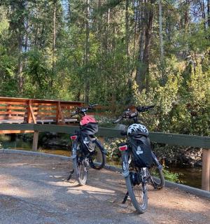 two bikes parked on a bridge next to a river