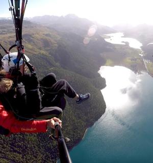 a man hanging from a parachute over a lake
