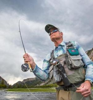 a man standing in a river holding a fishing rod