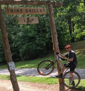 a man riding a bike under a street sign