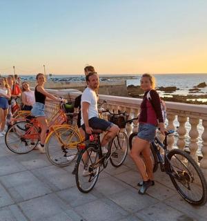a group of people riding bikes on the beach