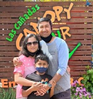 a family posing for a picture in front of a sign