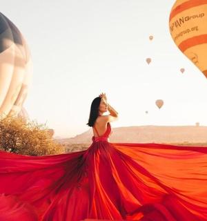 a woman in a red dress with hot air balloons
