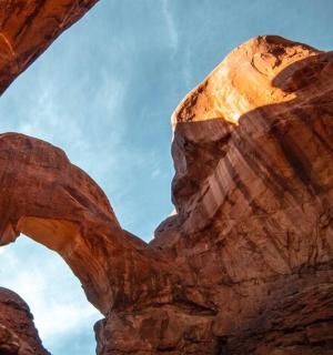 a person standing in an arch in the desert