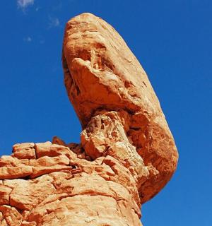 a close up of a croissant statue against a blue sky