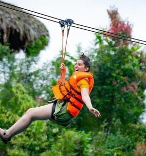 a woman is jumping on a zip line