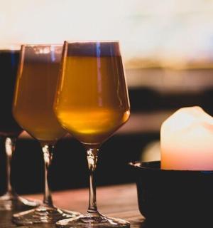 three wine glasses sitting on a table with a candle
