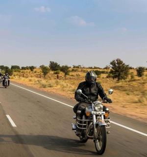 a group of motorcycles riding down the road