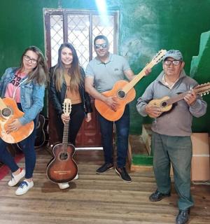 Un grupo de personas de pie en una habitación sosteniendo guitarras.