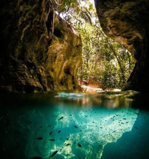 a cave with a pool of blue water in it