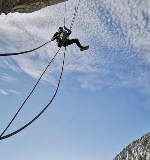 muž skáče z útesu do jeskyně