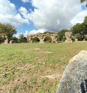 一个人站在田野里，旁边有一座石头建筑
