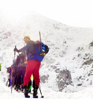 站在山顶上滑雪的人