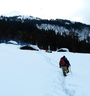 člověk kráčející sněhem na hoře