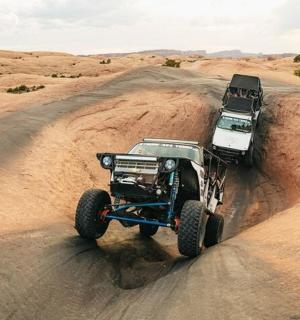 a jeep driving on a dirt road in the desert