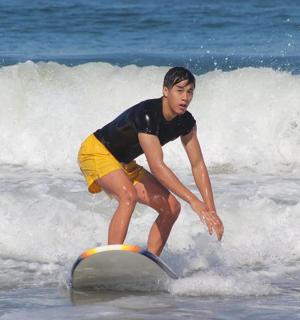 a young boy riding a wave on a surfboard in the ocean