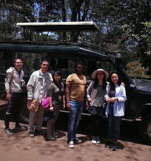 a group of people standing in front of a jeep