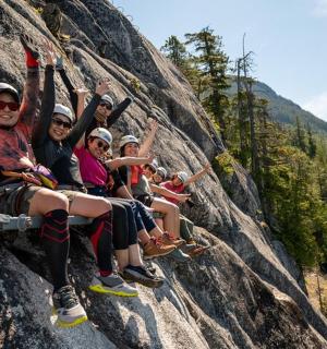 a group of people sitting on a rock wall