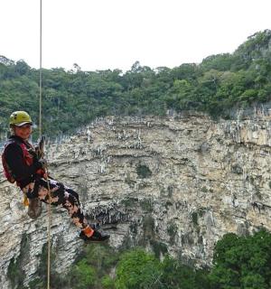 一名男子悬挂在悬崖上的绳子上
