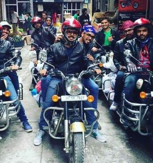 a group of men riding motorcycles down a street