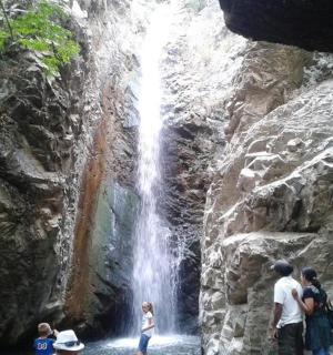 a group of people standing in front of a waterfall