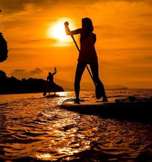 日落时分，两个人在水中划桨