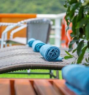 a wooden bench with blue rolled up towels on it
